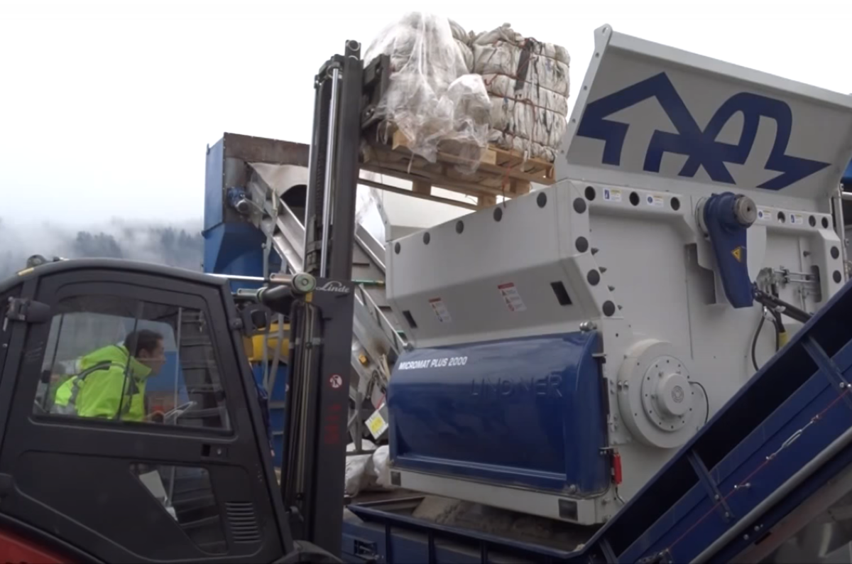 Worker loading shredder with waste